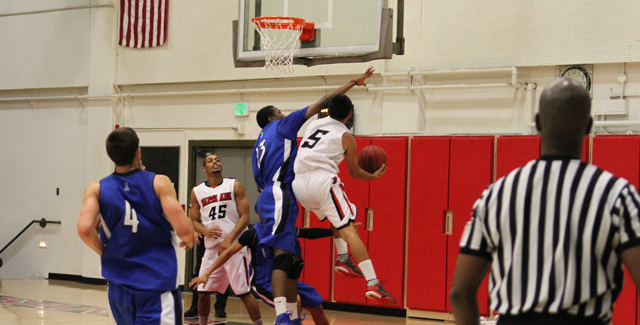Kevin Ramirez gets up a shot against a Cerritos defender in the Dons 92-81 win. Photo by Tony McAndrew