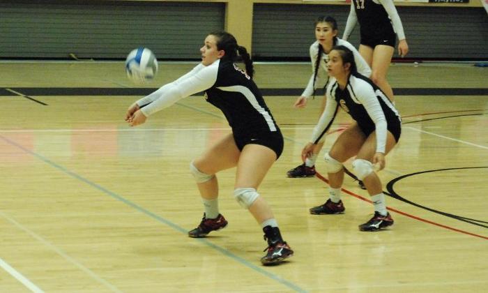 Madison Logan digs a ball against Fullerton College.