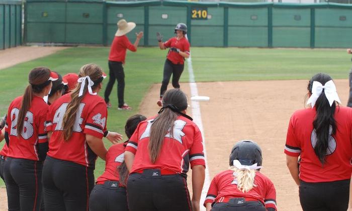 The Dons wait at home plate as Emily Whitecavage rounds third following her lead-off home run against Santiago Canyon College