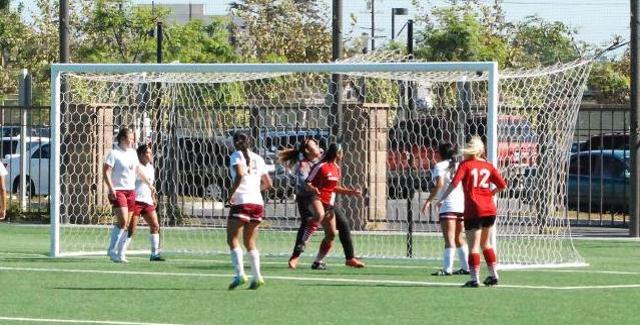 Syprus Ohanesian (center) watches the ball go into the goal as she scored the Dons first goal in OEC competition during SAC's 4-0 victory over Norco College.