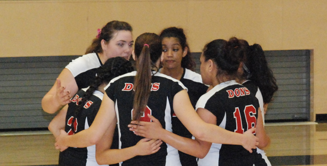 The Dons huddle up during a break in action as they controlled the third set.